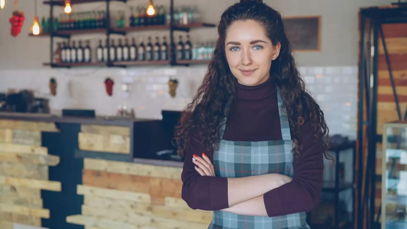 Google Business Profile optimization: cafe owner standing with arms crossed inside her shop