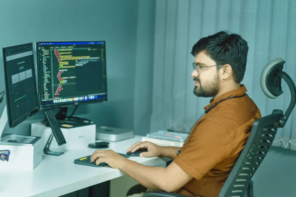 Developer writing code across two monitors Tree service SEO: developer writing code across two monitors