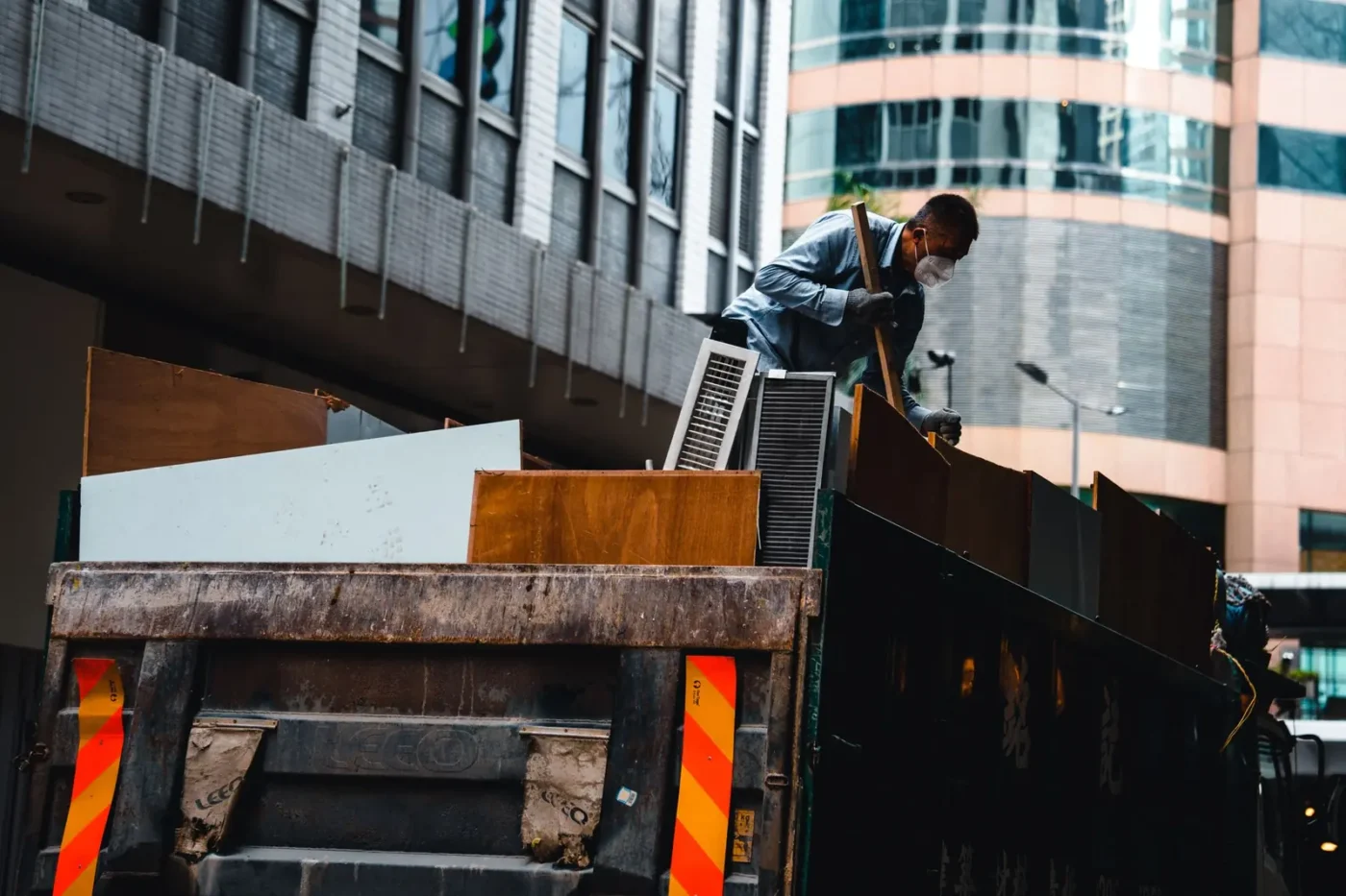 Junk removal marketing: worker loading debris onto a hauling truck