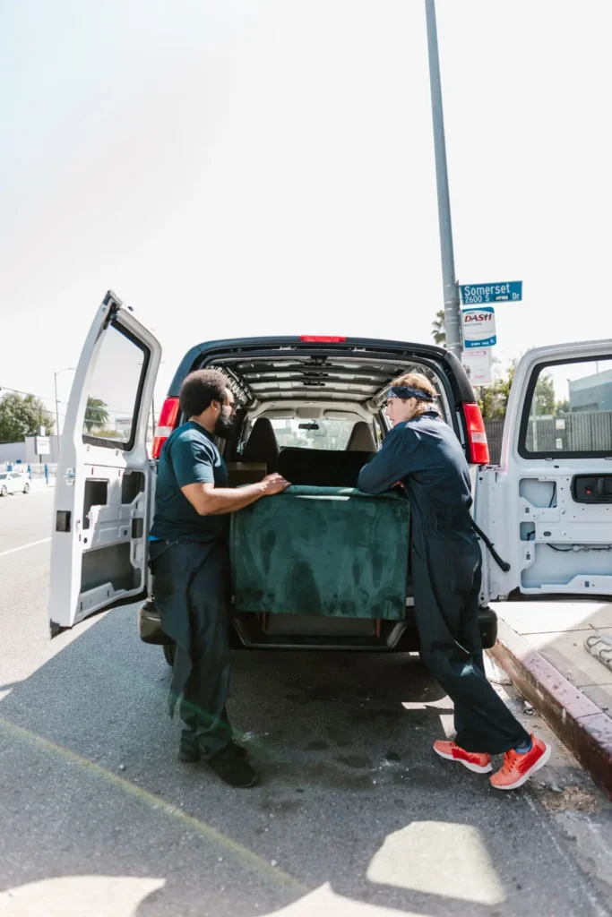 Junk removal marketing: two workers loading a sofa into the back of a van