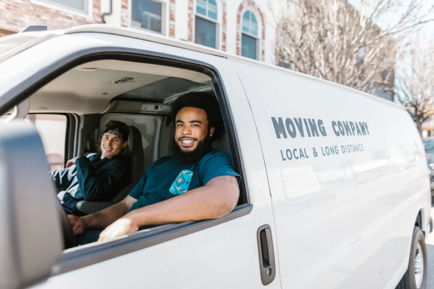 Two movers smiling from a moving company van Moving company marketing: two movers smiling from a moving company van