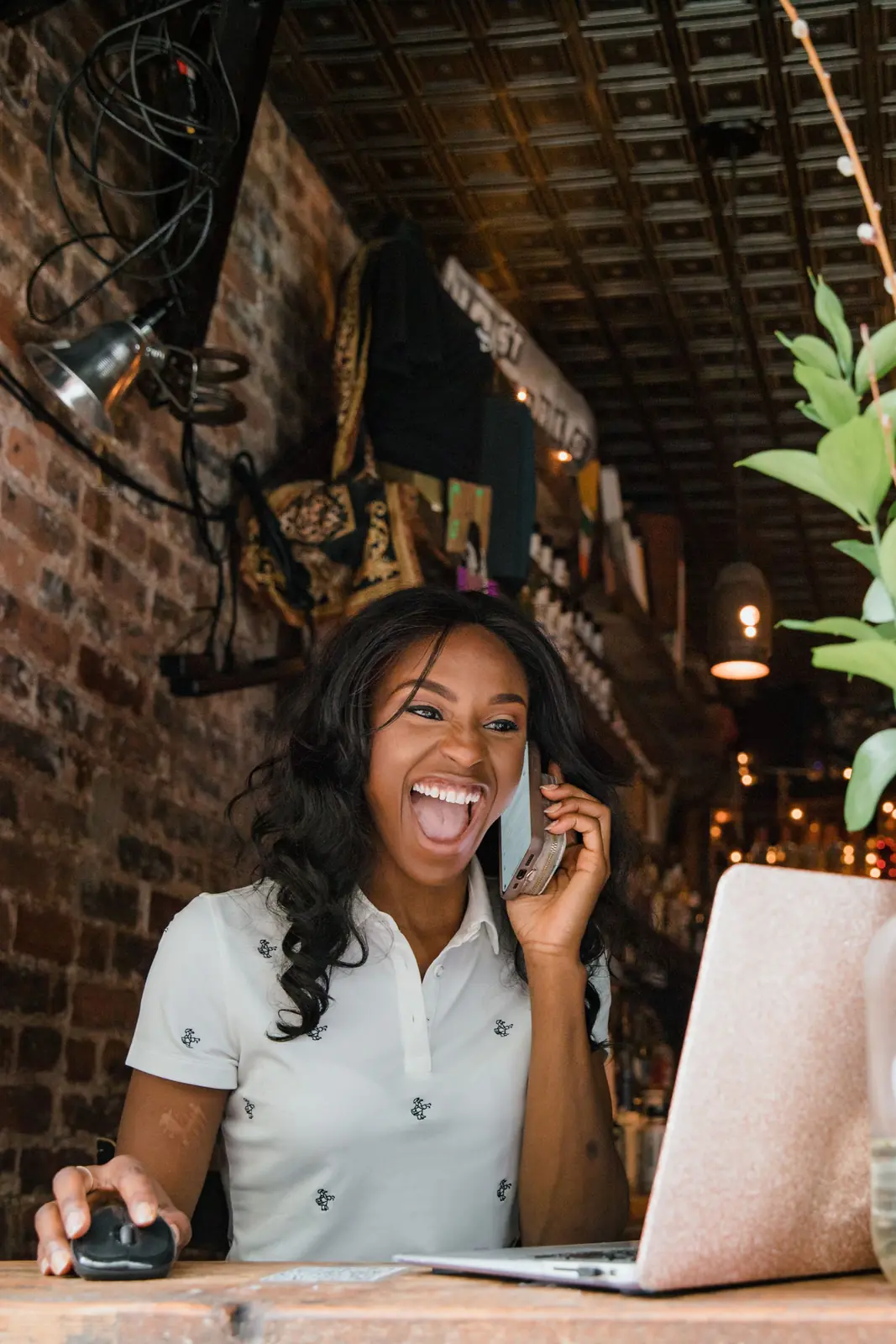 Small business owner laughing on a phone call at her laptop Lead generation services: small business owner laughing on a phone call at her laptop