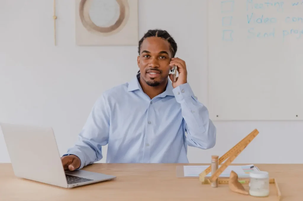 Google Ads management: business owner on a phone call while working on a laptop
