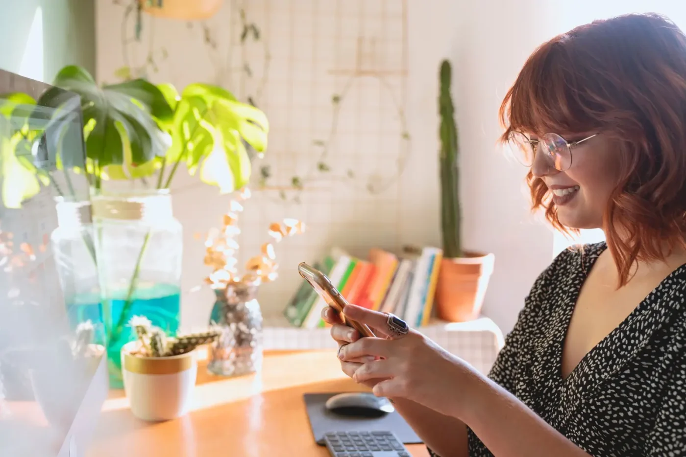 Reputation management services: woman smiling while reading on her phone at home
