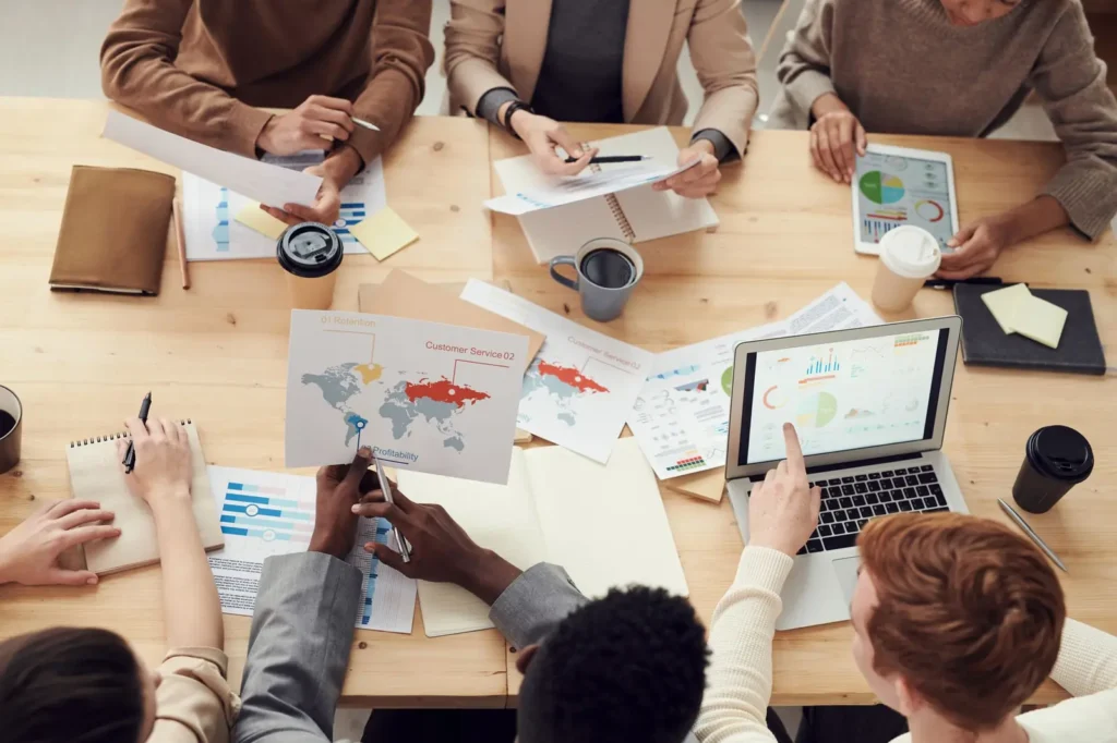 Digital marketing services: overhead view of a team planning with charts, notes and laptops