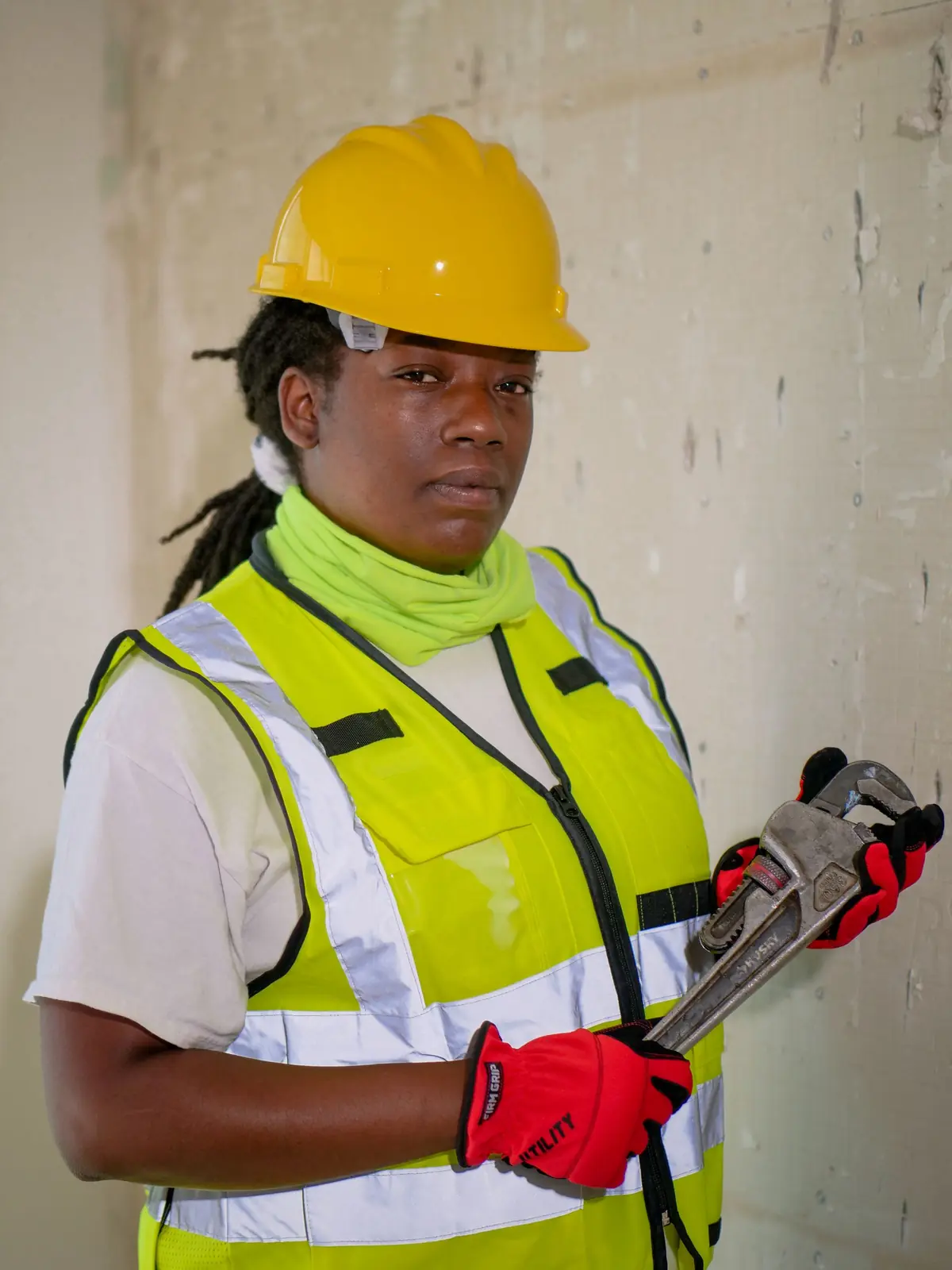 SEO for plumbers: plumber in a hard hat and safety vest holding a pipe wrench