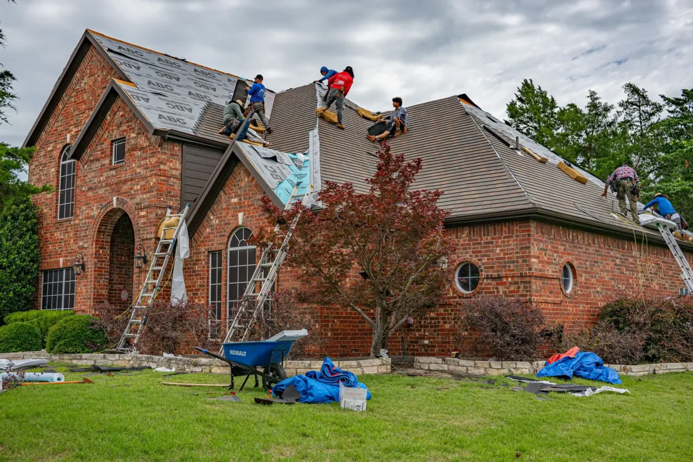 Roofing crew replacing shingles on a brick home Roofing marketing: roofing crew replacing shingles on a brick home