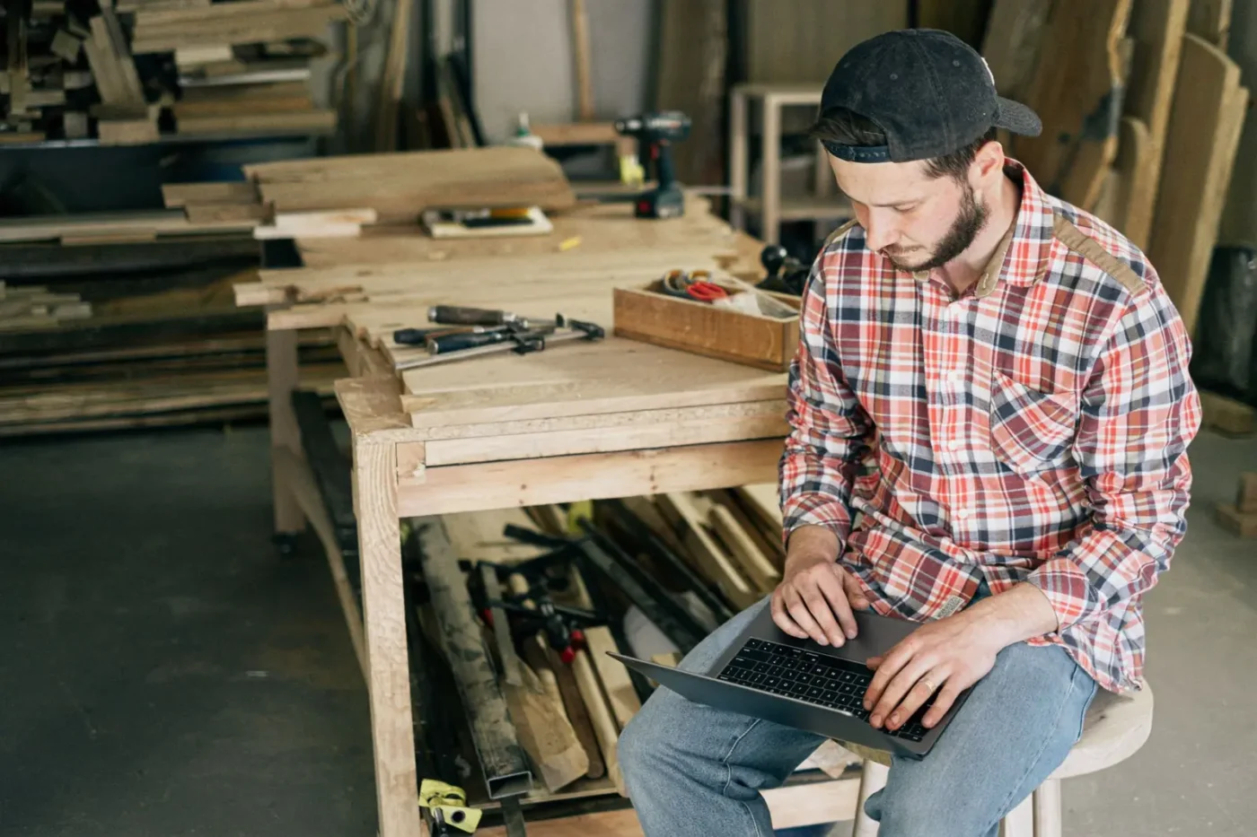 Google Ads management: tradesman in his workshop checking his laptop